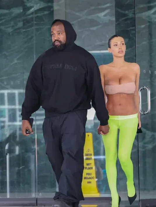 Penampilan Bianca Censori ini sempat mengejutkan netizen. Pasalnya, Bianca tampil super minim dan berani. Ia memadukan strapless top berwarna cokelat yang hanya menutupi payudaranya, dipadu legging hijau neon, dan high heels hitam. [Foto: Instagram/alwaysyzy]