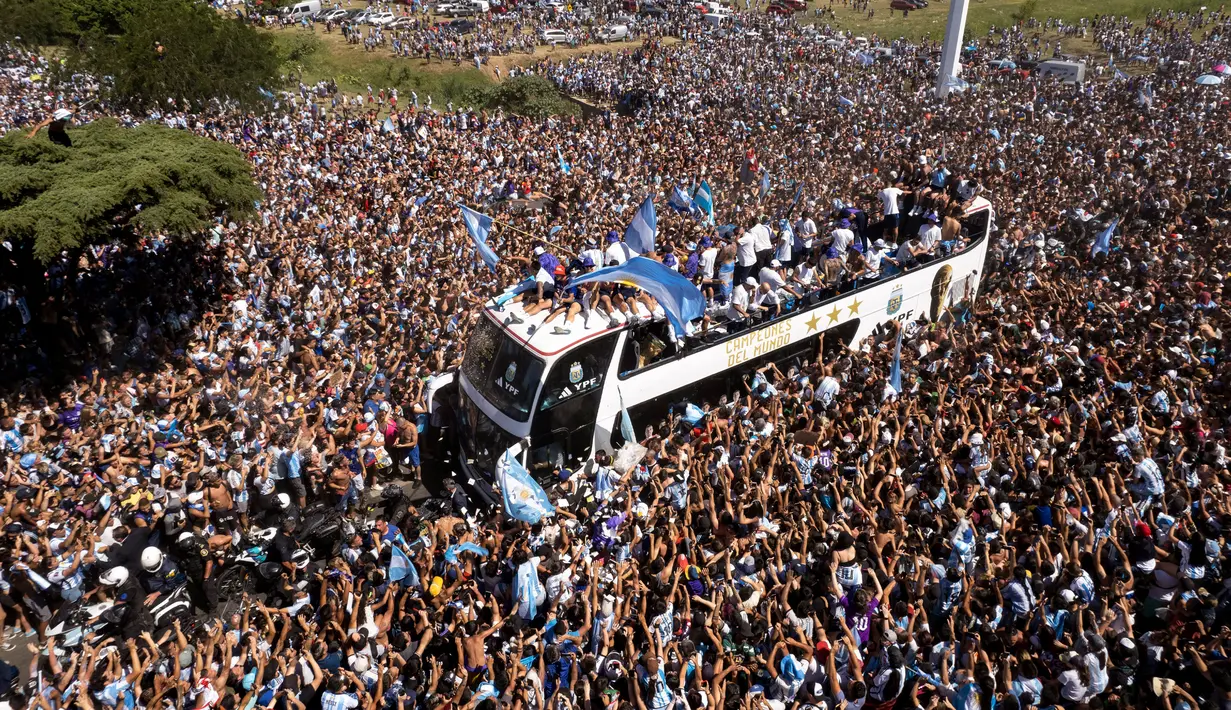 Timnas Argentina yang menjuarai Piala Dunia 2022 naik bus terbuka saat parade di Buenos Aires, Argentina, 20 Desember 2022. Jutaan orang menyambut kepulangan Lionel Messi dan kawan-kawan bak pahlawan usai Argentina menjuarai Piala Dunia 2022. (AP Photo/Rodrigo Abd)