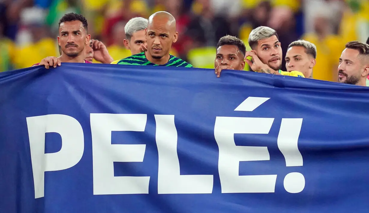 Para pemain Brasil membentangkan spanduk dukungan untuk Pele yang sedang sakit pada akhir pertandingan sepak bola babak 16 besar Piala Dunia 2022 antara Brasil dan Korea Selatan di Stadium 974, Doha, Qatar, 5 Desember 2022. (AP Photo/Jin-Man Lee)