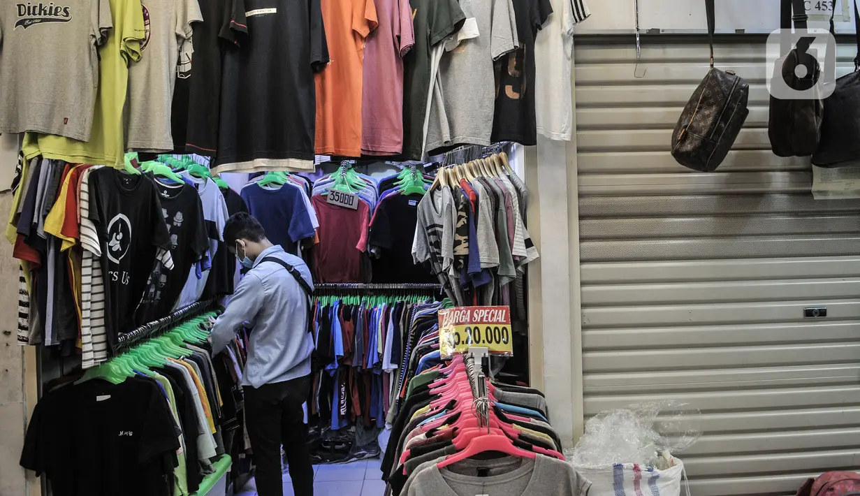 Pengunjung memilih pakaian bekas impor di Pasar Senen, Jakarta, Kamis (4/3/2021). Rudi (34) salah satu pedagang mengungkapkan penjualan pakaian bekas impor di Pasar Senen merosot hingga 50 persen sejak awal pandemi COVID-19 melanda Ibu Kota. (merdeka.com/Iqbal S. Nugroho)