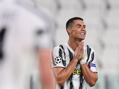 Penyerang Juventus, Cristiano Ronaldo, tampak kecewa usai kalah agregat oleh Olympique Lyon dan tersingkir dari Liga Champions 2019/2020 di Stadion Allianz, Sabtu (8/8/2020) dini hari WIB. Juventus kalah agregat 2-2 atas Olympique Lyon. (AFP/Miguel Medina)