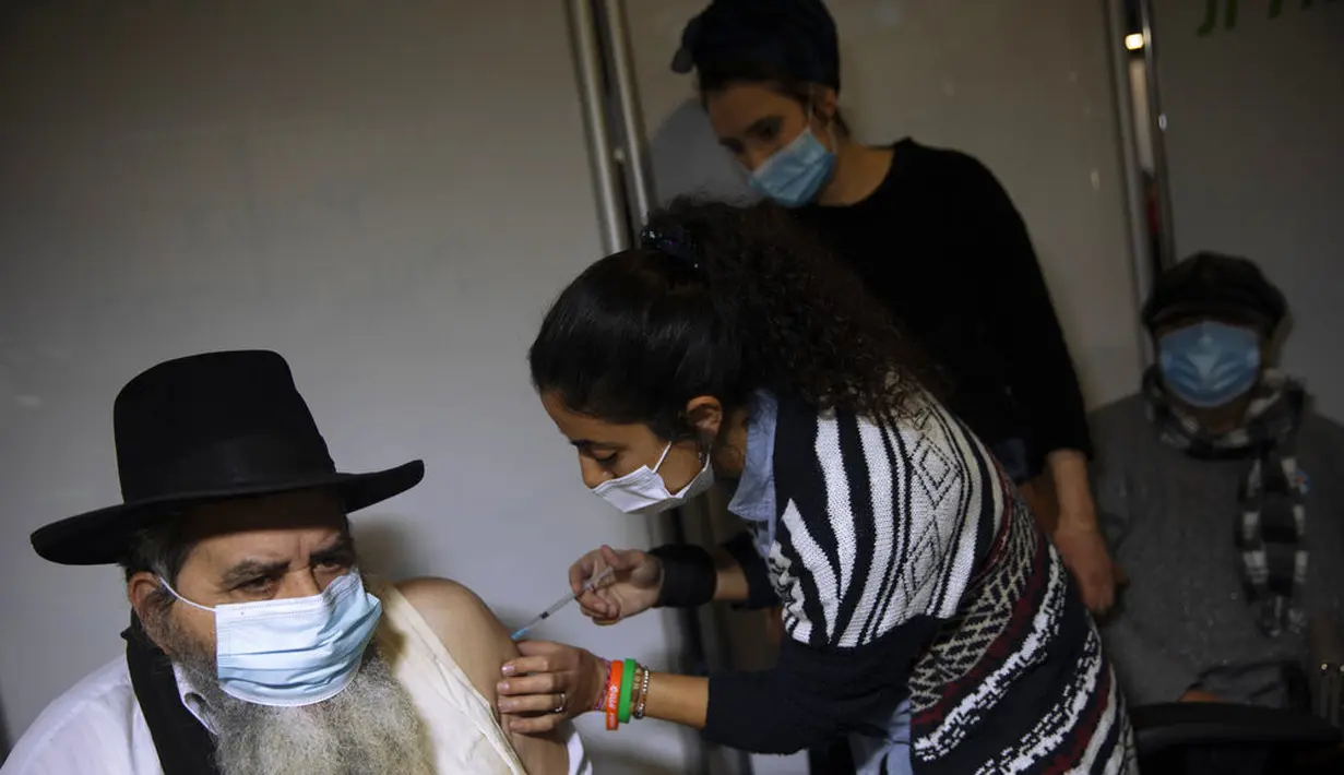 Seorang pria menerima vaksin virus corona COVID-19 dari staf medis di Pusat Vaksinasi COVID-19, Yerusalem, Senin (4/1/2021). Israel telah memberikan vaksin virus corona COVID-19 kepada lebih dari satu juta orang. (AP Photo/Oded Balilty)