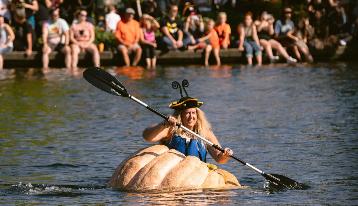 Emma Gray, dari Tualatin, mendayung labu raksasa menuju garis finish dalam event West Coast Giant Pumpkin Regatta di Tualatin, Oregon, Amerika Serikat pada 16 Oktober 2022. Labu raksasa yang sudah dilubangi tersebut dijadikan kano untuk lomba mendayung. (Photo by Wesley Lapointe / AFP)