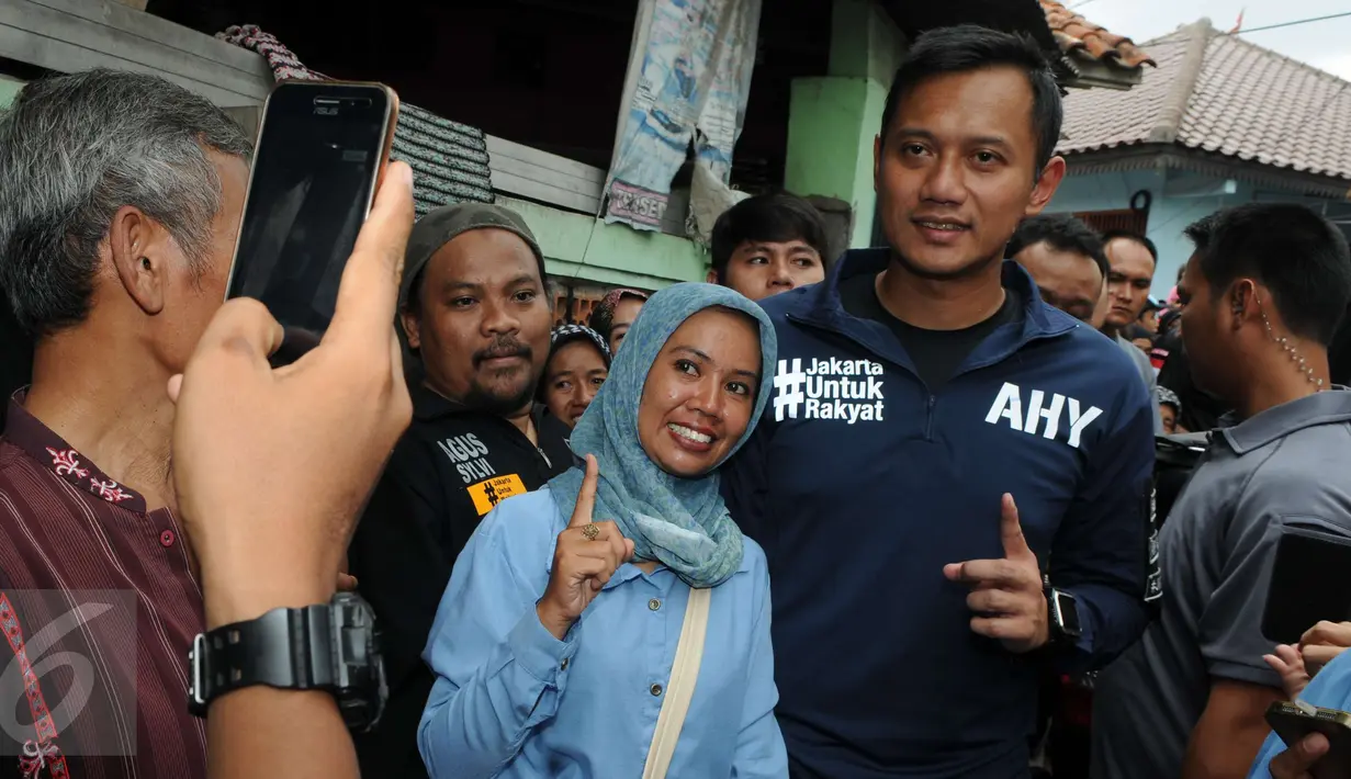 Calon Gubernur DKI Jakarta Agus Harimurti Yudhoyono berfoto bersama warga saat mengunjungi perkampungan Tegal Parang, Mampang Prapatan, Jakarta, Selasa (7/12). AHY dicurhati warga sekitar seputar penyelesaian masalah banjir. (Liputan6.com/Helmi Afandi)