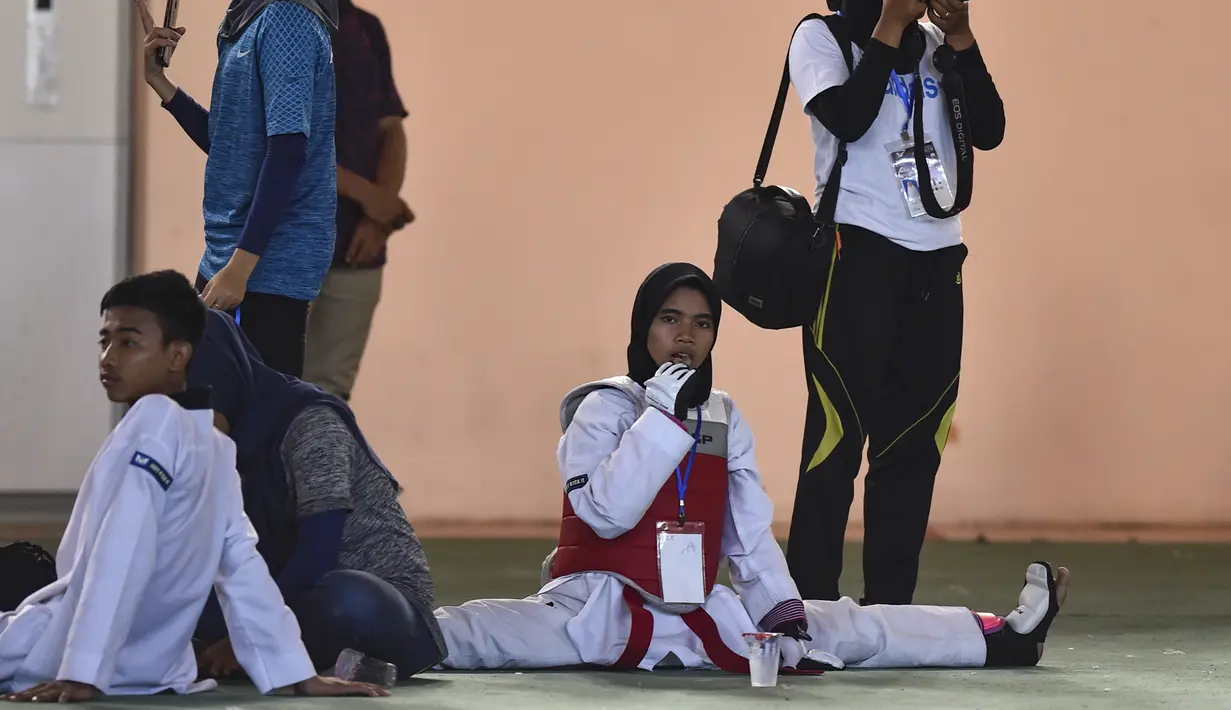Peserta perempuan melakukan pemanasan sebelum bertanding pada Kejuaraan Terbuka Taekwondo di Banda Aceh (17/7/2019). Kejuaraan Taekwondo ini berlangsung 12-18 Juli 2019. (AFP Photo/Chaideer Mahyuddin)