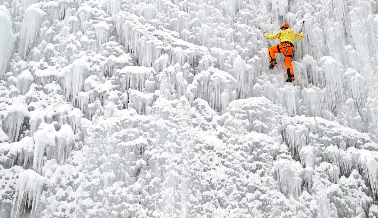 Seorang pria memanjat dinding es buatan di kota Liberec, Republik Ceko, Minggu (27/1). Meski buatan, tidak sembarang orang bisa menaklukkan tebing es tersebut. (AP Photo/Petr David Josek)