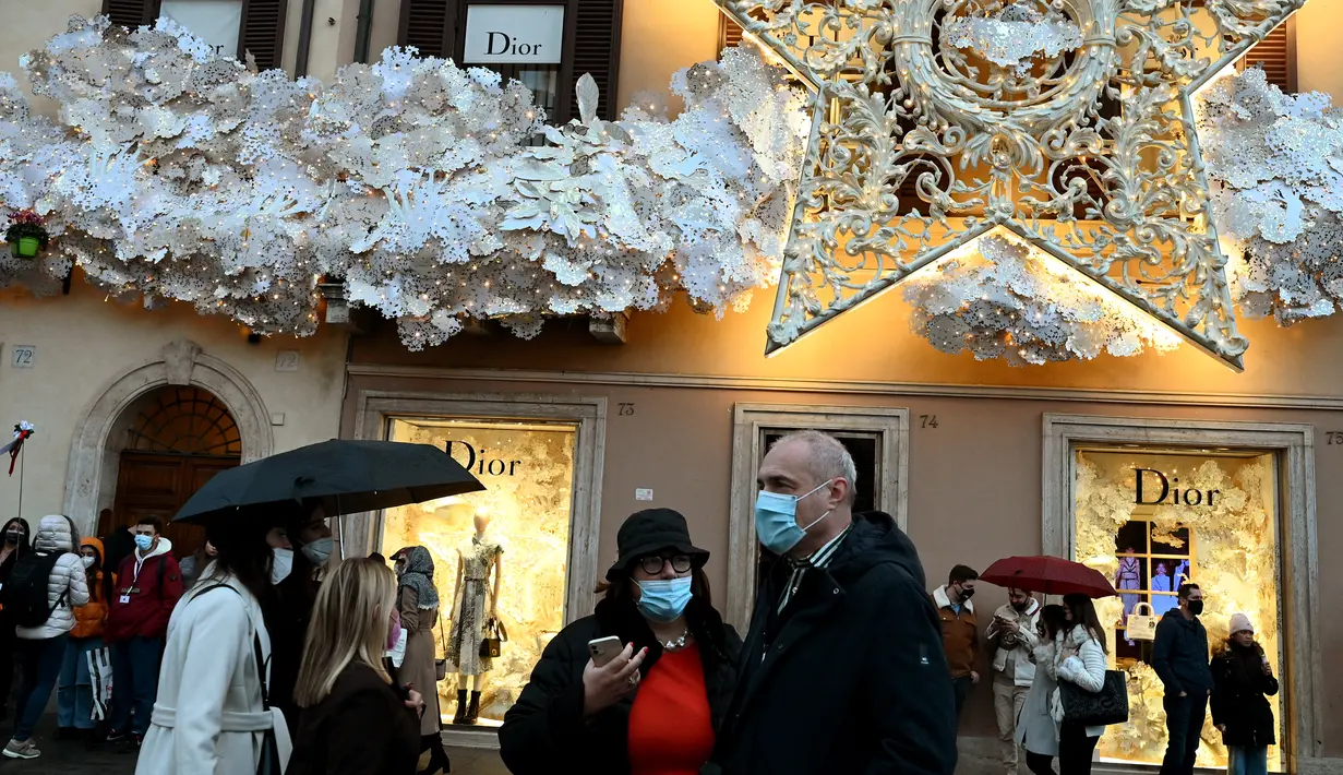 Orang-orang mengenakan masker di Piazza di Spagna di Roma tengah, Italia, Minggu (5/12/2021). Kota Roma memberlakukan kewajiban penggunaan masker di ruang terbuka pusat kota dan area perbelanjaan sibuk lainnya hingga 31 Desember mendatang. (Vincenzo PINTO/AFP)