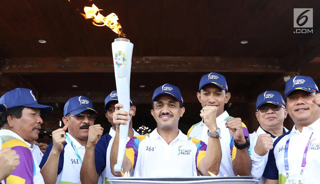 Pelari bersiap membawa obor Asian Games 2018 dalam Torch Relay Asian Games 2018 di kawasan TMII, Jakarta, Rabu (15/8). Kota Jakarta menjadi persinggahan terakhir api Asian Games yang dimulai dari wilayah Jaktim dan Jaksel. (Liputan6.com/Immanuel Antonius)