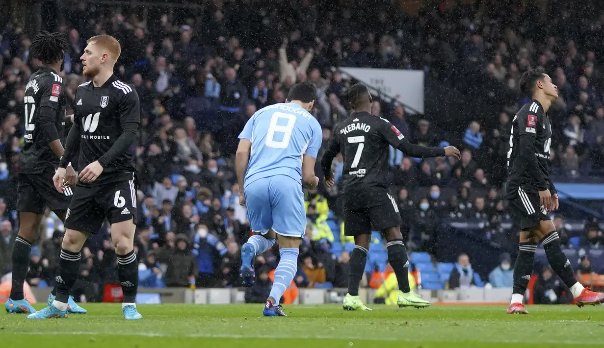 Hanya butuh dua menit, Manchester City berhasil menyamakan skor 1-1. Gol dicetak via sontekan Ilkay Guendogan (tengah) yang tidak mampu dibendung kiper Fulham Paulo Gazzaniga usai menerima umpan Riyad Mahrez. (AP/Jon Super)