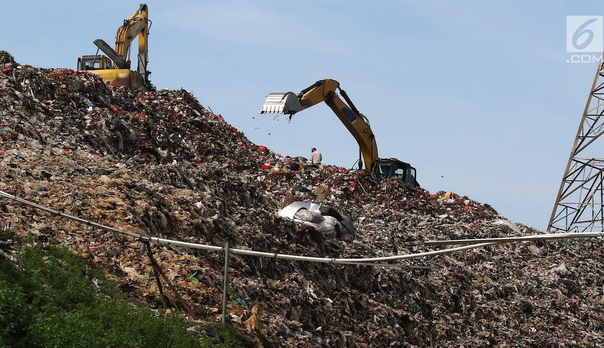 Alat berat mengeruk sampah yang menggunung di Tempat Pembuangan Akhir (TPA) Cipayung, Depok, Jawa Barat, Jumat (28/12). TPA tersebut menampung sampah Kota Depok. (Liputan6.com/Immanuel Antonius)
