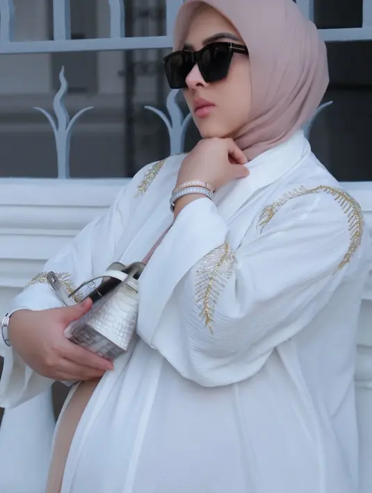 Lengkapi busananya, Syahrini konsisten jinjing Hermes Himalayan KMini Kelly dan hijab coral nude. [@princessyahrini]