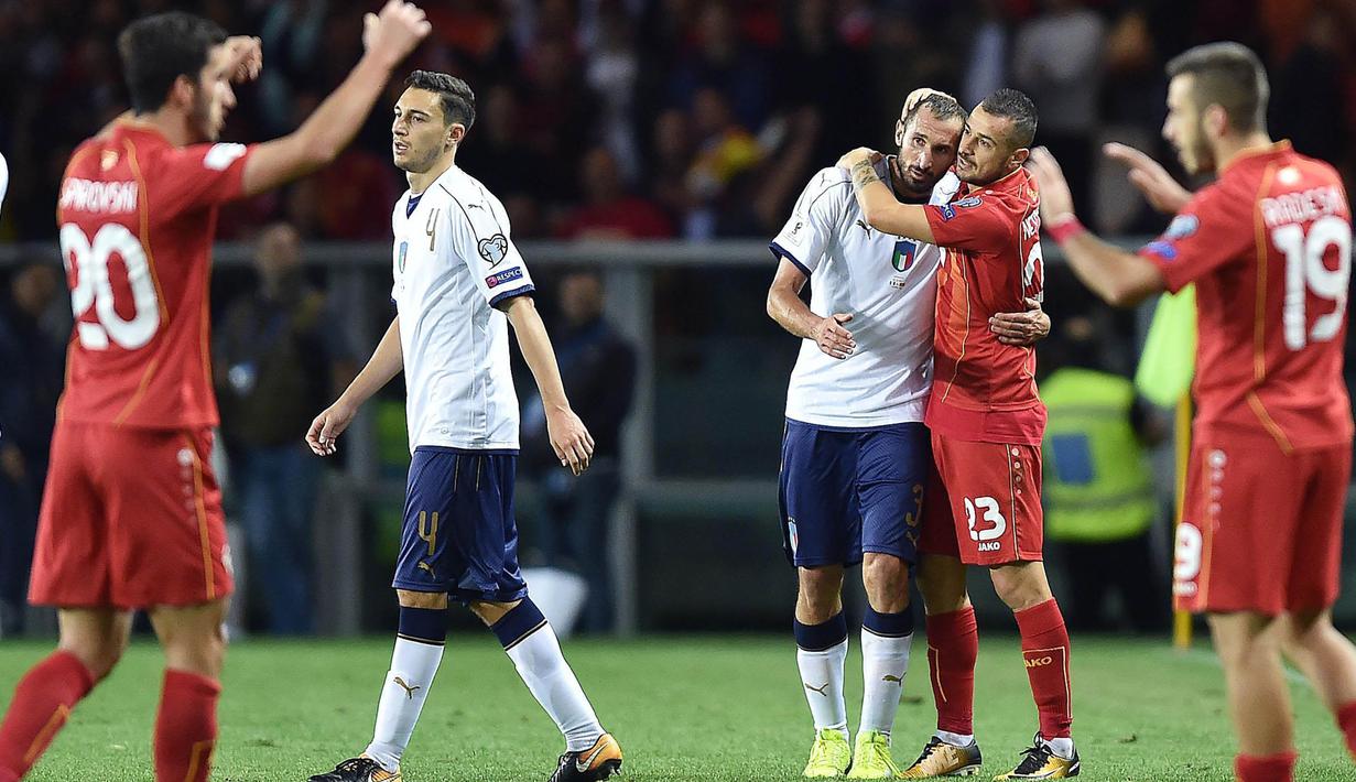 Striker Makedonia, Ilija Nestorovski, memeluk bek Italia, Giorgio Chiellini, pada laga Kualifikasi Piala Dunia 2018 di Stadion Olimpico, Turin, Jumat (6/10/2017). Italia ditahan imbang 1-1 dengan Makedonia. (AP/Alessandro Di Marco)