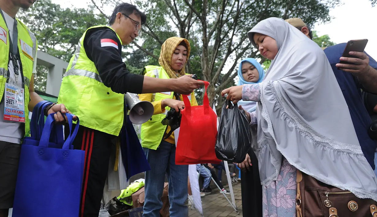 Aktivis lingkungan membagikan kantong belanja nonplastik saat sosialisasi pengurangan penggunaan kantong plastik di Sempur, Bogor, Minggu (25/11). Perwali Kota Bogor tentang kantong plastik akan belaku mulai 1 Desember 2018. (Merdeka.com/Arie Basuki)