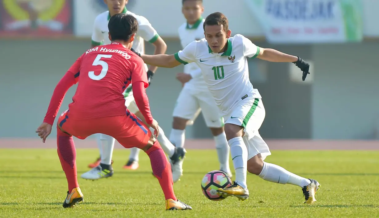 Gelandang Timnas Indonesia U-19, Egy Maulana (kanan) berusaha melewati pemain Korea Selatan, Kim Hyunwoo pada laga ketiga kualifikasi Piala Asia U-19 2018 di Paju Public Stadium, Korsel (4/11). Timnas kalah 4-0 dari Korsel. (AFP Photo/Kim Doo-Ho)