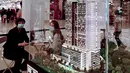 Agen real estat mempromosikan bangunan apartemen bertingkat tinggi di pusat perbelanjaan di Penang (1/8/2020). Malaysia tengah memperingatkan gelombang kedua virus corona COVID-19. (AFP Photo/Goh Chai Hin)