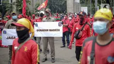 Petugas Satpol PP memegang poster imbauan protokol kesehatan COVID-19 saat unjuk rasa buruh di depan Gedung DPR, Jakarta, Selasa (17/11/2020). Pemerintah terus mengingatkan pentingnya 3M yaitu memakai masker, menjaga jarak, dan mencuci sebagai upaya pencegahan Covid-19. (Liputan6.com/Faizal Fanani)
