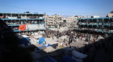 Warga Palestina berdiri di halaman sekolah Al-Jawni (Jaouni) setelah serangan udara Israel menghantam lokasi tersebut, di Nuseirat, Jalur Gaza tengah pada 11 September 2024. (Eyad BABA/AFP)