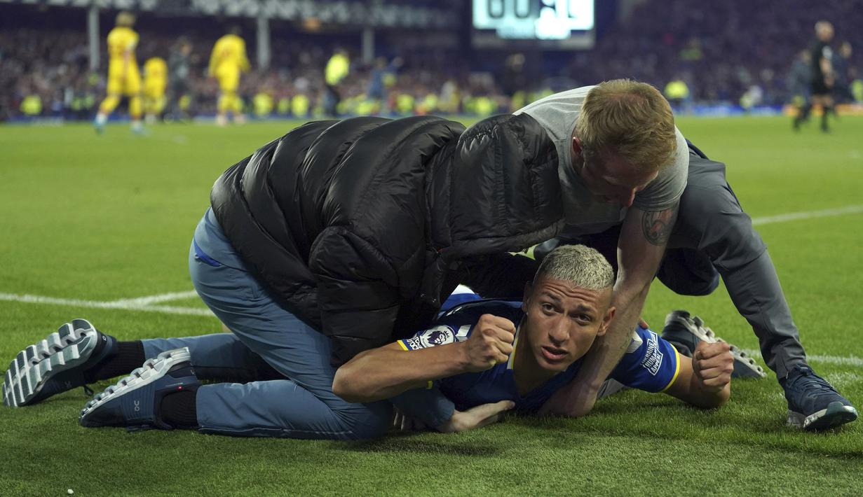 Penyerang Everton, Richarlison, melakukan selebrasi dengan para suporter Everton yang merayakan akhir pertandingan Liga Inggris antara Everton dan Crystal Palace di Goodison Park di Liverpool, Inggris, 19 Mei 2022. Everton berhasil menang lewat come back dramatis 3-2 dan keluar dari zona degradasi Liga Inggris. (AP/Jon Super)