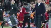 Pelatih Liverpool, Jurgen Klopp memeluk gelandang Takumi Minamino usai ditarik keluar pada pertandingan melawan Everton di babak ketiga Piala FA di Anfield, Minggu (5/1/2020). Minamino bermain selama 70 menit, lalu digantikan Alex Oxlade-Chamberlain. (AP Photo/Jon Super)