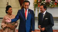 Presiden  Joko Widodo bersama ibu negara Iriana menyambut  Sultan Brunei Hassanal Bolkiah di Istana Merdeka, Minggu (20/10/2019). Sultan Brunei Darussalam Hassanal Bolkiah menjadi tamu negara pertama yang diterima oleh Jokowi. (AFP Photo/Bay Ismoyo)