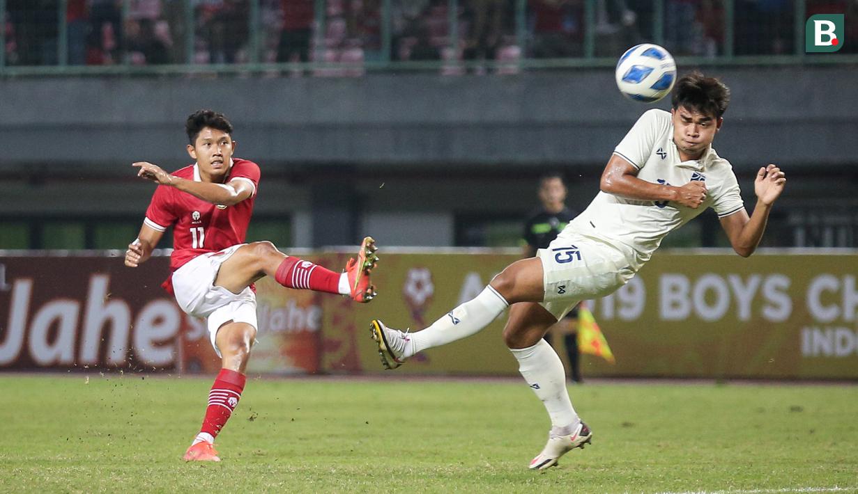 <p>Pemain Timnas Indonesia U-19,&nbsp;Ferdiansyah Cecep Surya&nbsp;menendang&nbsp;bola&nbsp;dihadang pemain Timnas Thailand U-19, Bukkoree&nbsp;Lemdee dalam pertandingan babak penyisihan Grup A Piala AFF U-19 yang berlangsung di Stadion Patriot Candrabhaga, Bekasi, Rabu (6/7/2022). (Bola.com/Bagaskara Lazuardi)</p>