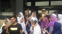 Dua pemain Timnas Indonesia, Stefano Lilipaly dan Irfan Bachdim, melayani permintaan fans yang menunggu di depan hotel tim pada Senin (2/10/2017). (Bola.com/Benediktus Gerendo Pradigdo)