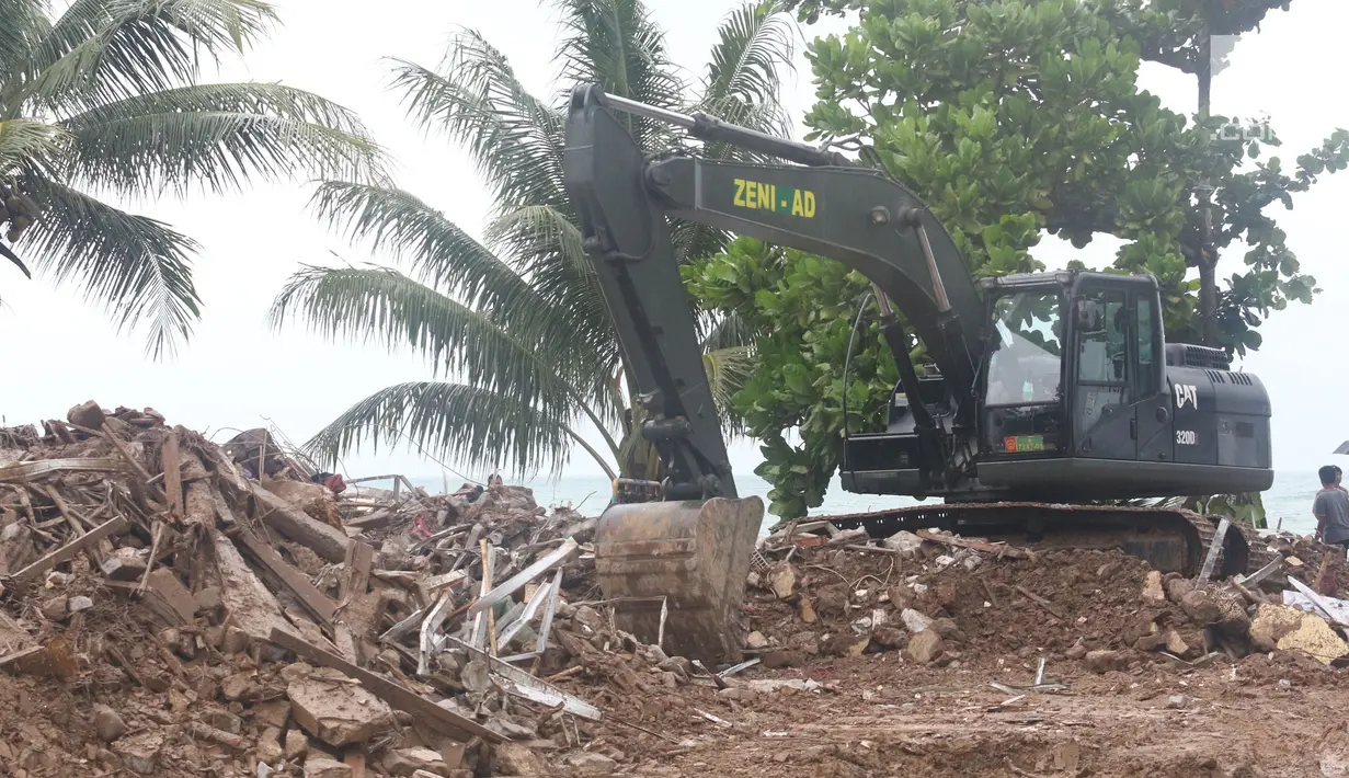 Alat berat melakukan evakuasi bangunan yang hancur akibat terjangan tsunami Selat Sunda di Carita, Banten, Selasa (25/12). Akibat tsunami yang melanda kawasan tersebut menyebakan ratusan rumah dan mobil rusak. (Liputan6.com/Angga Yuniar)