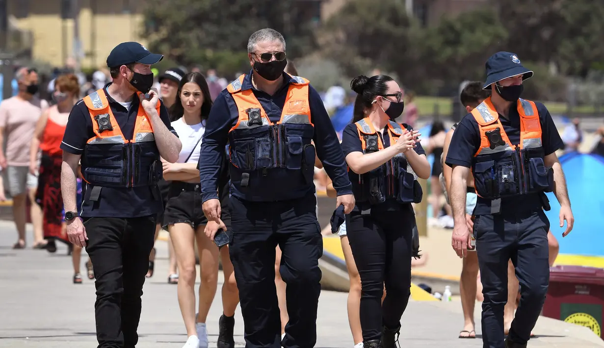 Petugas keamanan berpatroli di Pantai St Kilda Melbourne, Australia (3/11/2020). Negara bagian Victoria di Australia mencatat nol kasus penularan virus corona (Covid-19) selama empat hari berturut-turut setelah berjuang melawan gelombang kedua wabah pandemi. (AFP/William West)