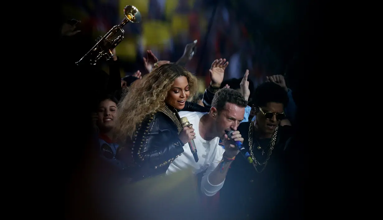 Aksi Beyonce, Chris Martin dari Coldplay dan Bruno Mars ketika tampil pada halftime show Super Bowl 50 yang dihelat di Levi’s Stadium di Santa Clara, California, Minggu (7/2). (TIMOTHY A. CLARY / AFP)