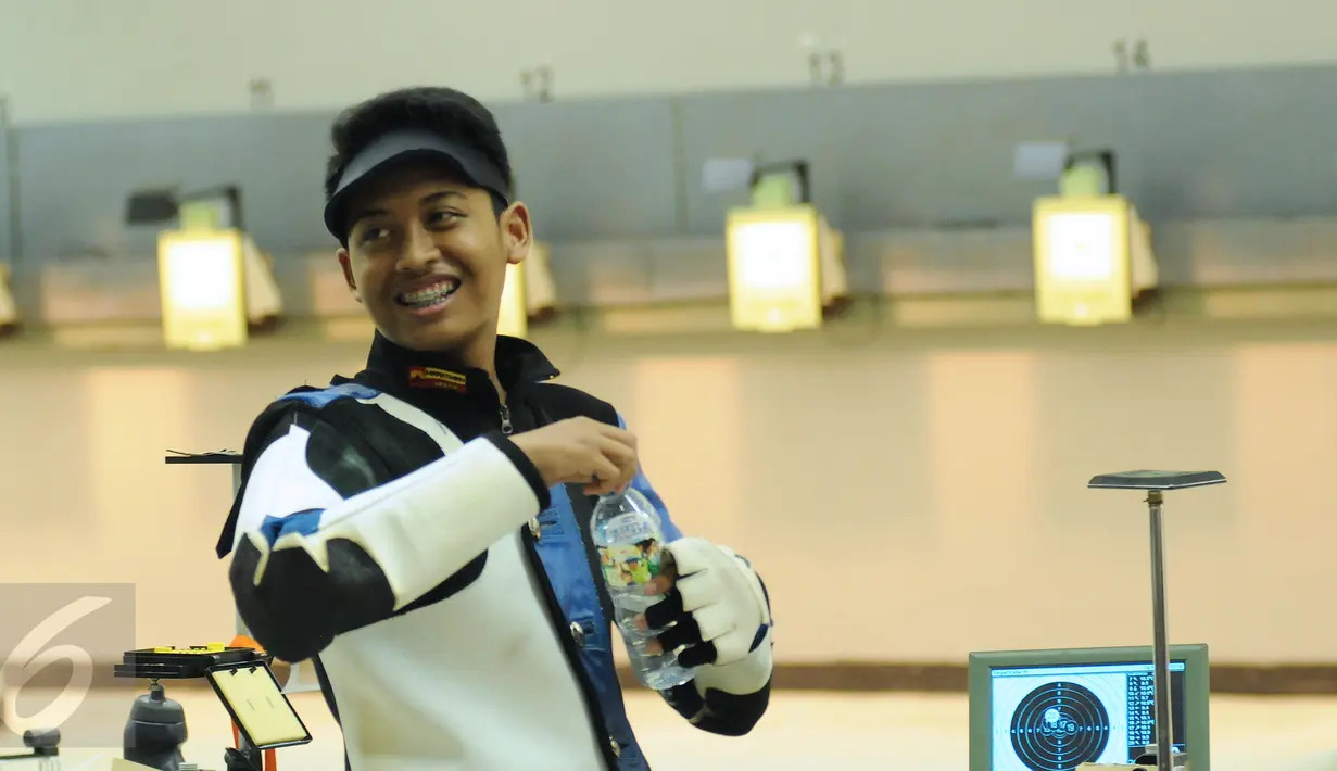 Petembak Junior Indonesia, Fathur Gustafian tersenyum usai memastikan tempat kedua Final 10m Air Rifle Men Junior Kejuaraan Menembak ASEAN di Jakarta, Selasa (24/11/2015). Fathur kalah 2.8 poin dari petembak Singapura. (Liputan6.com/Helmi Fithriansyah)