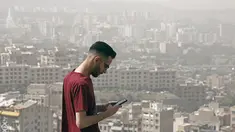Seorang pria berdiri di atas bukit selama badai pasir hebat yang melanda utara ibu kota Iran, Teheran pada 17 Mei 2022. Kantor-kantor pemerintah, serta sekolah dan universitas diumumkan ditutup di banyak provinsi di Iran karena kondisi "cuaca tidak sehat" dan badai pasir yang menyelimuti, menurut laporan media pemerintah. (AFP)