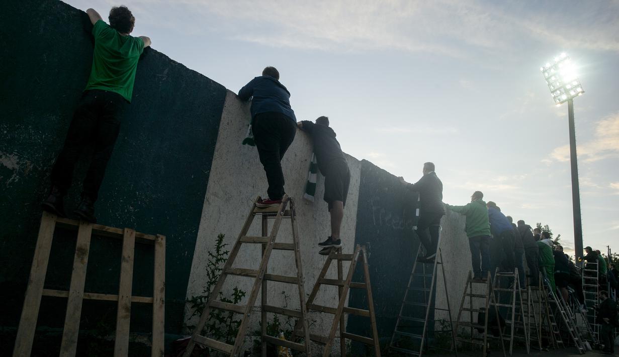 Suporter Bohemians 1905 menyaksikan pertandingan melawan Sparta Praha pada laga Liga Fortuna di Praha, Rep. Ceko (6/6/2020). Laga tertutup karena pembatasan virus corona tersebut membuat fans menonton dari balik tembok. (AFP/Michal Cizek)
