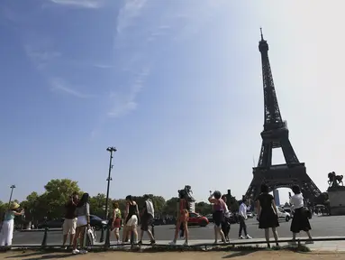 Wisatawan menuju ke Menara Eiffel di Paris, Rabu (31/8/2022). Pariwisata kembali dengan sepenuh hati ke Prancis musim panas ini, mengirimkan pendapatan melebihi tingkat pra-pandemi menurut data pemerintah yang dirilis minggu ini. (AP Photo/Aurelien Morissard)