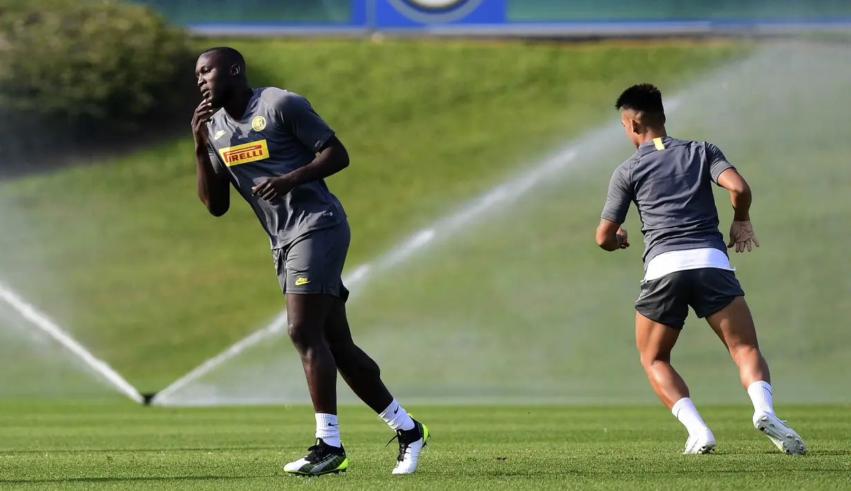 Penyerang Inter Milan, Romelu Lukaku (kiri) dana Lautaro Martinez melakukan pemanasan selama sesi latihan tim di Appiano Gentile, Italia (16/9/2019). Inter Milan akan bertanding melawan Slavia Praha pada grup F Liga Champions di Giuseppe Meazza, Italia. (AFP Photo/Miguel Medina)