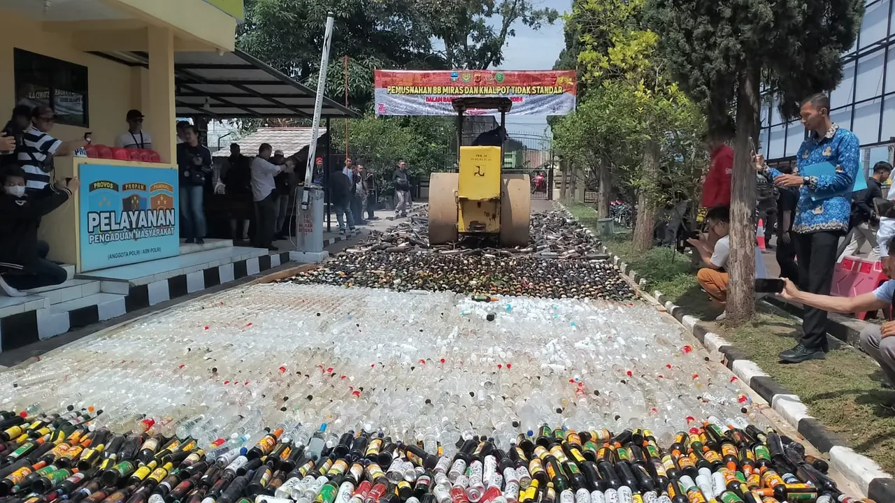 Kepolisian resort Garut, Jawa Barat memusnahkan ribuan botol minuman keras (miras) berbagai merk dan knalpot brong, selama Juli-September 2024. (Liputan6.com/Jayadi Supriadin)
