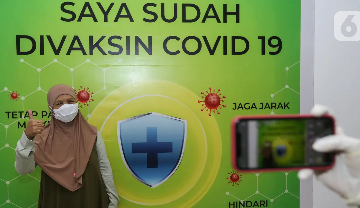 Warga Lansia foto dengan latar belakang Saya Sudah Divaksin Covid-19 di Cibubur Junction, Jakarta, Senin (22/03/2021). Warga lansia ber KTP DKI Jakarta atau yang tinggal di Jakarta Timur bisa menjalani vaksin mulai pukul 10.00 - 16.00 WIB hingga Sabtu 27 Maret. (Liputan6.com/Fery Pradolo)