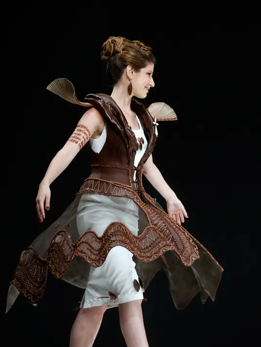 Seorang model mengenakan gaun cokelat saat berjalan di atas catwalk sebuah pameran yang dikombinasikan dengan fashion show di Paris, 27 Oktober 2017. Pameran tersebut bertajuk Salon Du Chocolat. (AP Photo/Thibault Camus)