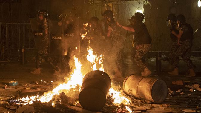 Polisi antihuru-hara bergerak maju untuk mendorong kembali pengunjuk rasa antipemerintah selama protes terhadap elite politik yang telah memerintah negara selama beberapa dekade di Beirut, Lebanon, Jumat (7/8/2020). (AP Photo/Hassan Ammar)