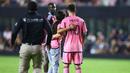 Seorang gadis memasuki lapangan untuk berswafoto dengan Lionel Messi pada laga lanjutan Major League Soccer (MLS) antara Inter Miami melawan Colorado Rapids di Fort Lauderdale, Florida, Amerika Serikat, Minggu (07/04/2024) WIB. (AFP/Megan Briggs)