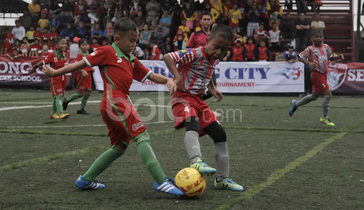 Tim ATKL Tigers Malaysia berebut bola dengan pemain CISS (merah) dalam final Plate U-8 Serpong City International Soccer Tournament di Sabnani Park, Tangerang Selatan. Minggu (4/12/2016). (Bola.com/Arief Bagus)