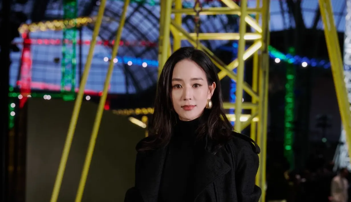 Aktris Taiwan Ning Chang tampil dengan gaya minimalis yang sophisticated. Ia memadukan turtleneck hitam dengan tailored trousers berwarna beige yang diberi aksen sabuk merah marun. Lapisan coat hitam dengan potongan clean line menambah kesan elegan, sementara clutch kecil dan anting emas melengkapi tampilan yang polished serta effortless.