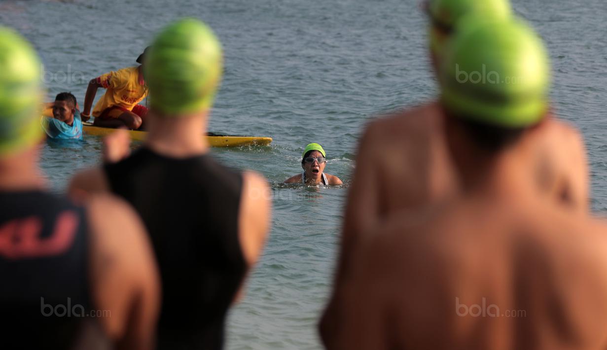 Seorang peserta wanita Rhino Cross Triathlon berusaha menyelesaikan lomba renang pada Festival Pesona Tanjung Lesung 2017 di Tanjung Lesung, Banten (24/9/2017). Total jarak tempuh Rhino Cross Triathlon 38 km. (Bola.com/Nicklas Hanoatubun)