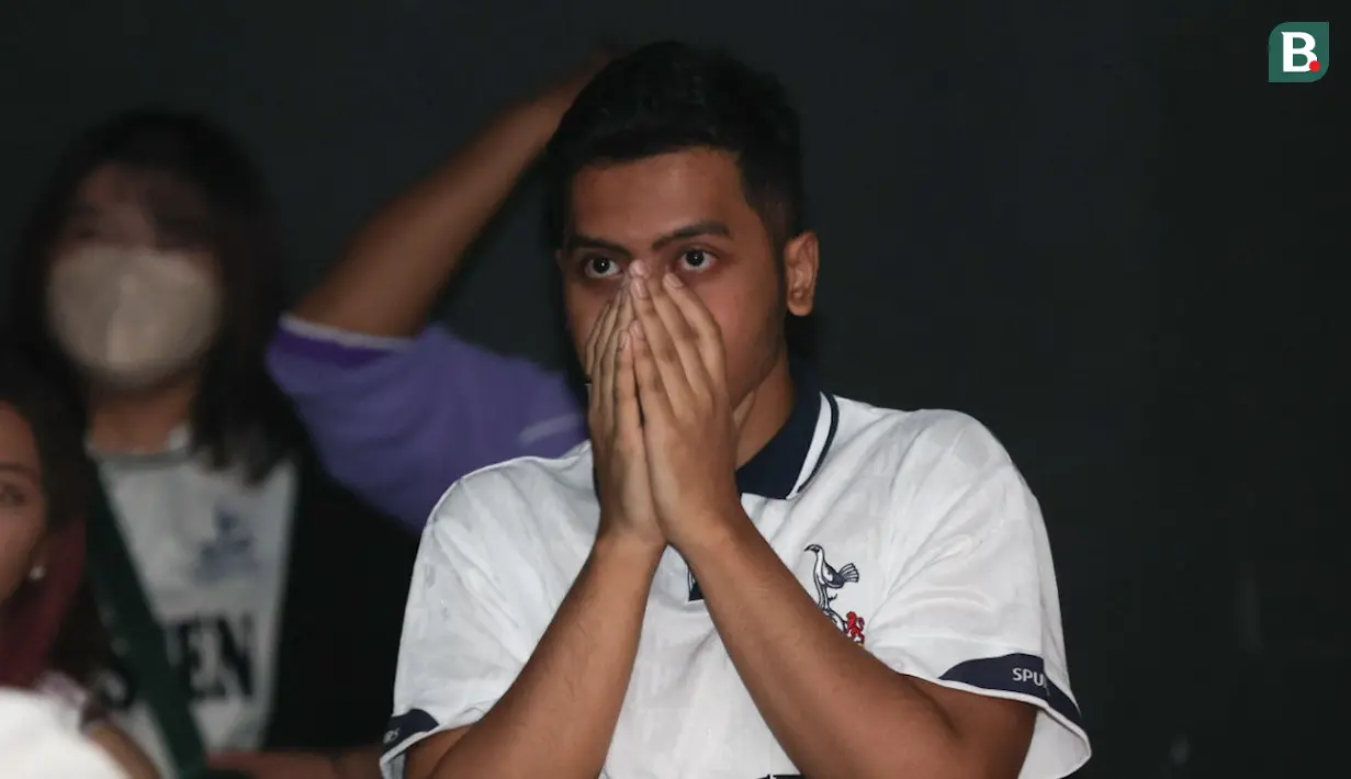 Ekspresi tegang seorang penggemar Tottenham Hotspur saat menyaksikan tim kesayangannya menghadapi Arsenal dalam acara nonton bareng Roaring Night Liga Inggris 2023/2024 di Treehaus Kemang, Minggu (28/4/2024) malam WIB yang digelar komunitas penggemar Tottenham Hotspur, IndoSpurs Jakarta. (Bola.com/Abdul Aziz)