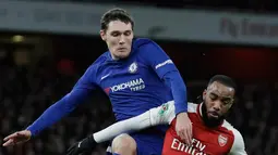 Pemain Arsenal, Alexandre Lacazette berebut bola dengan pemain Chelsea, Andreas Christensen pada laga leg kedua babak semifinal Piala Liga di Stadion Emirates, Kamis (25/1). Tiket final Piala Liga jatuh ke tangan Arsenal usai menang 2-1. (AP/Matt Dunham)