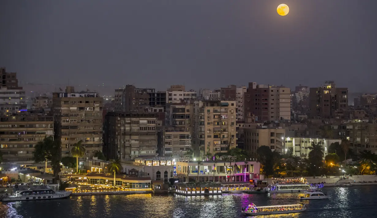 Bulan Purnama Stroberi atau Strawberry Full Moon muncul di atas ibu kota Mesir, Kairo, pada Kamis (24/6/2021). Strawberry Full Moon adalah istilah yang diambil dari hikayat atau cerita tradisi dari suku-suku asli Amerika. (Khaled DESOUKI / AFP)