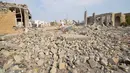 Seorang pria berjalan di reruntuhan bangunan pusat kebudayaan yang dikelola pemerintah Yaman setelah serangan udara Saudi di kota pelabuhan Laut Merah di Hodeidah, Yaman (2/9). (REUTERS/Abduljabbar Zeyad)