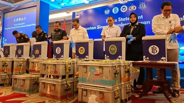 Jajaran pimpinan Bank Indonesia dan kepolisian secara simbolis memasukkan uang rupiah palsu ke dalam wadah pembuangan mesin pencacah. Pemusnahan ini mengikuti prosedur ketat. (Liputan6.com/Arief)