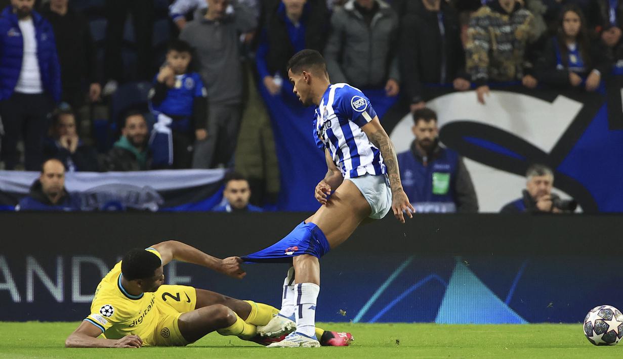Pemain Inter Milan, Denzel Dumfries (kiri) berusaha merebut bola dari pemain Porto, Galeno dengan menarik celananya hingga melorot pada laga leg kedua 16 besar Liga Champions 2022/2023 di Drago Stadium, Porto, Rabu (15/03/2023) WIB. (AP Photo/Luis Vieira)