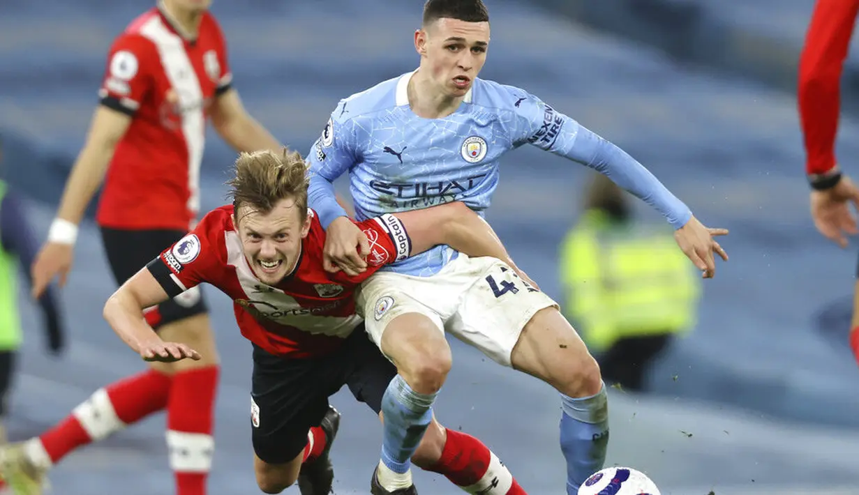 Pemain Manchester City, Phil Foden, berebut bola dengan pemain Southampton, James Ward-Prowse, pada laga Liga Inggris di Stadion Etihad, Kamis (11/3/2021). City menang dengan skor 5-2. (Clive Brunskill/Pool via AP)