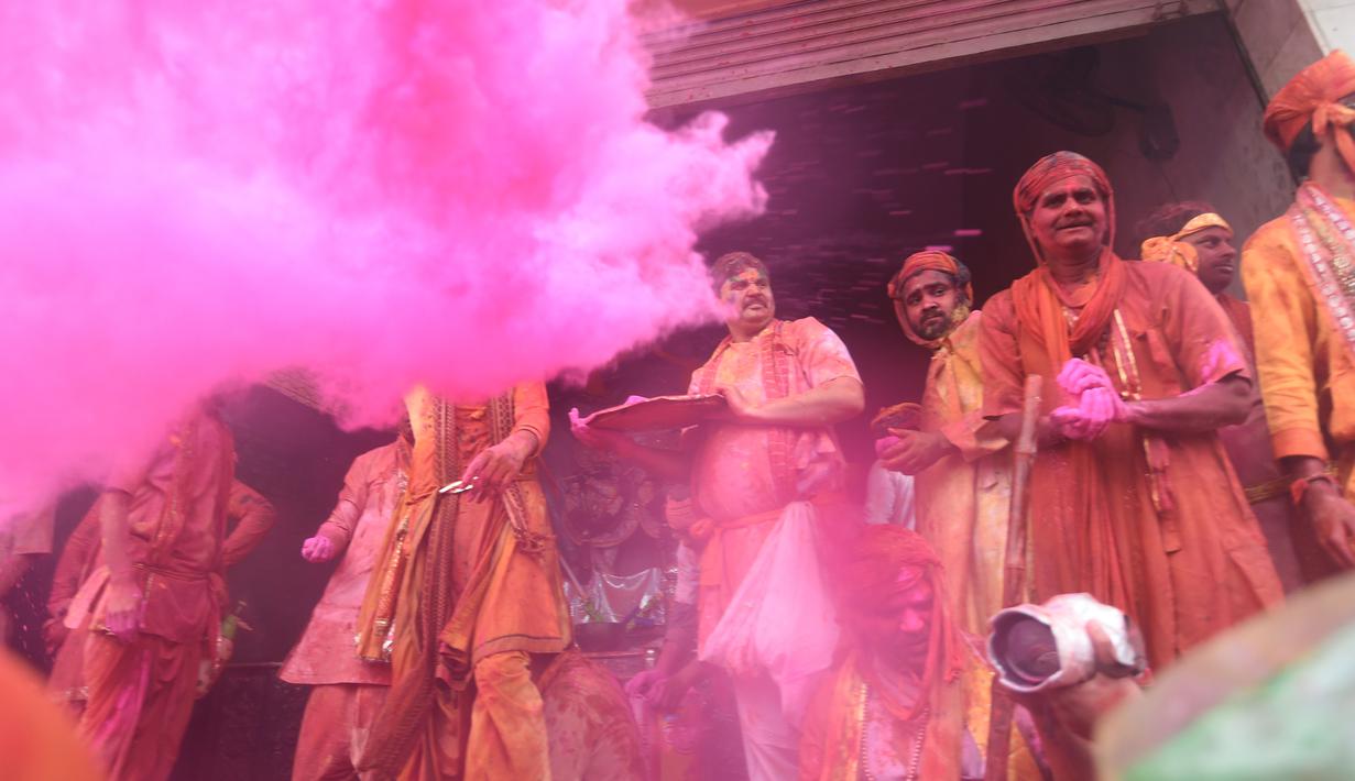 Umat Hindu India merayakan Holi, festival warna musim semi, di sebuah kuil di desa Nandgaon, negara bagian Uttar Pradesh, 5 Maret 2020. Festival Holi diselenggarakan pada awal musim semi yaitu pada akhir Februari hingga Maret, tepatnya sesudah bulan purnama. (Money SHARMA/AFP)